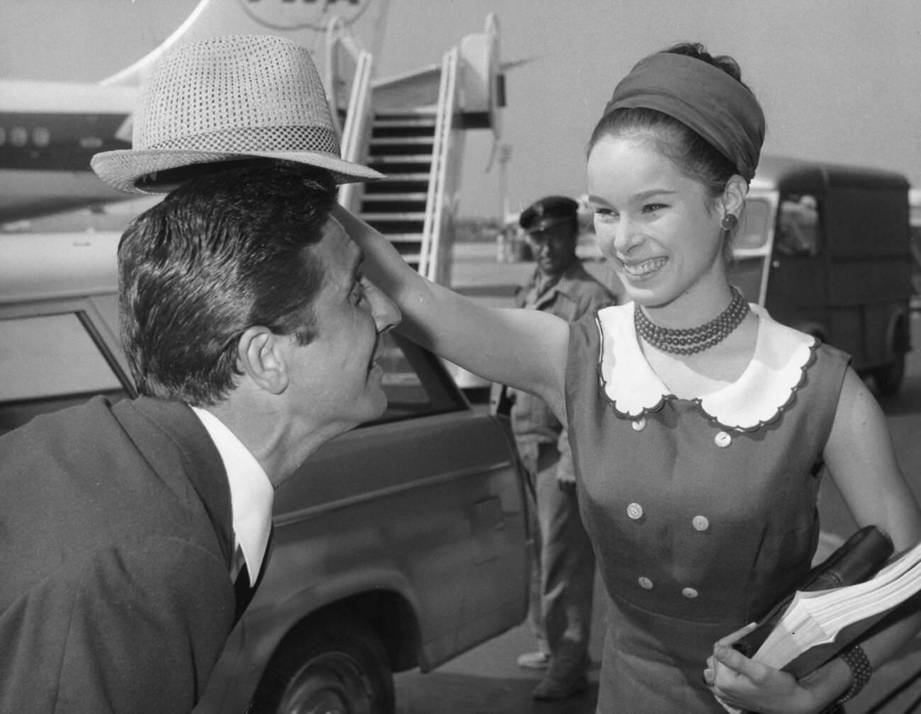 Geraldine Chaplin Having Fun With Gilbert Becaud Before Boarding A Plane, July 3, 1964.