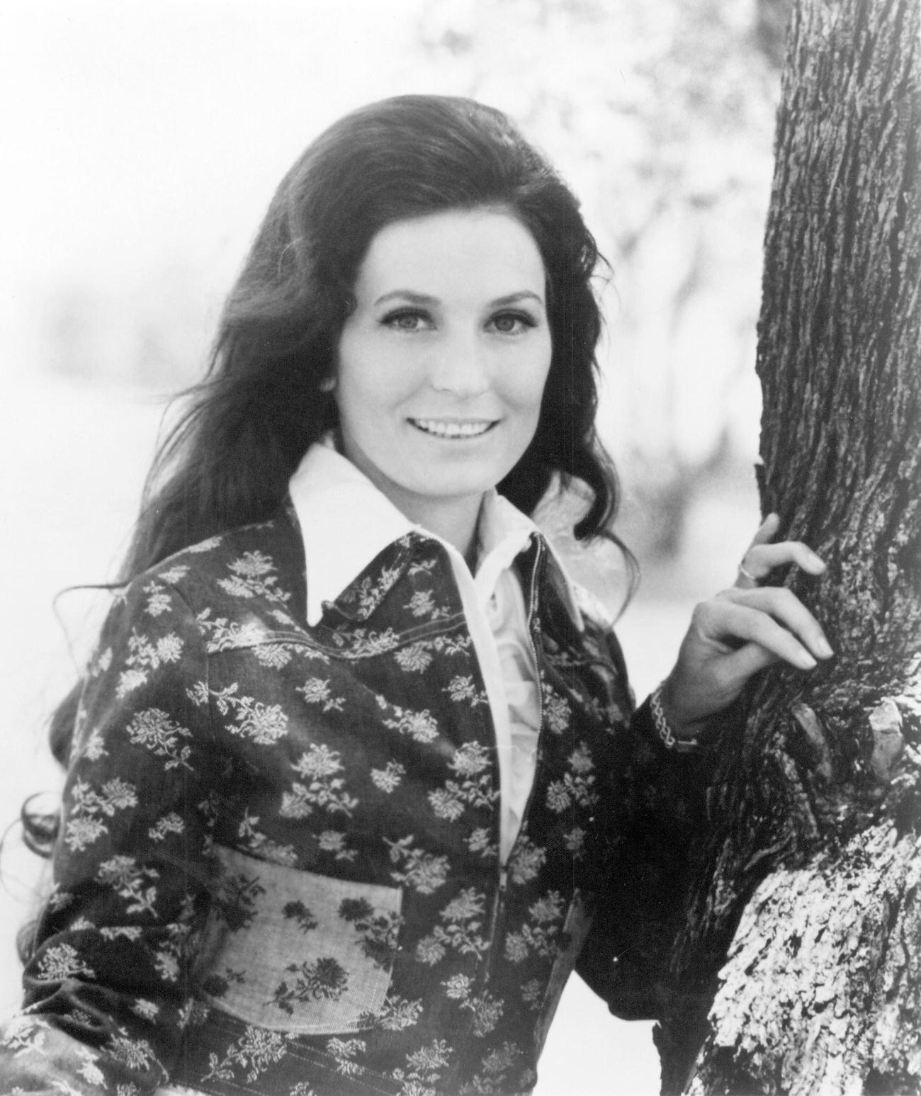 Loretta Lynn Poses For A Portrait Leaning Against A Tree, Circa 1975.