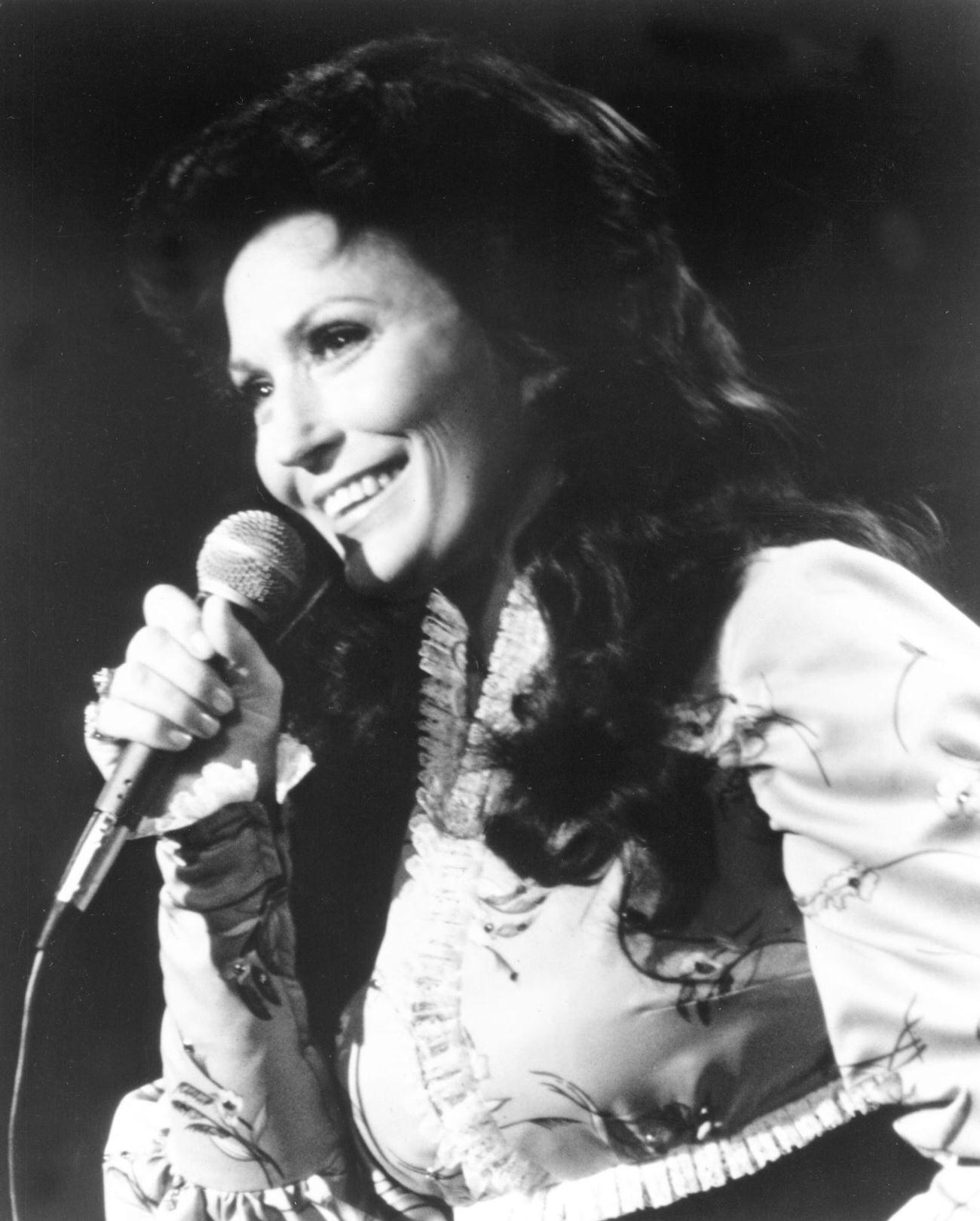 Loretta Lynn Performs Onstage With A Microphone, Circa 1975.
