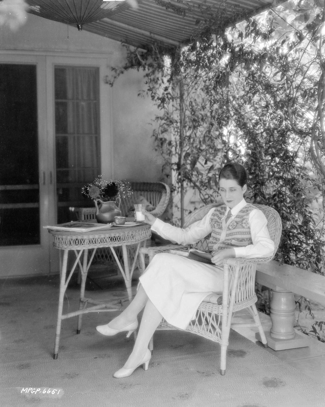 Norma Shearer Reading A Book On A Wicker Chair On A Shady Verandah, July 17, 1925.