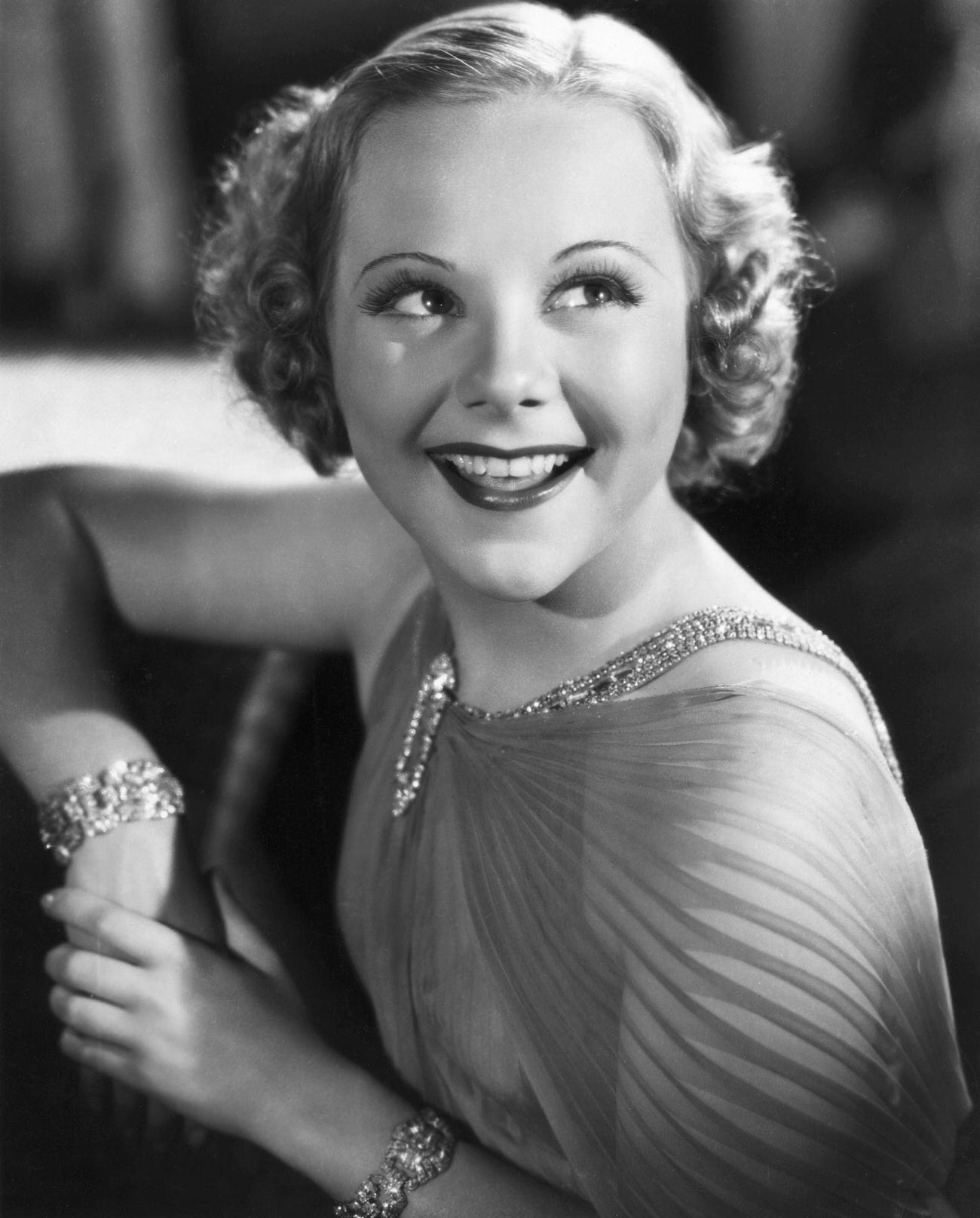 Sonya Henie, Wearing A Diaphanous Gown And Sparkling Jewelry, Smiling Broadly.