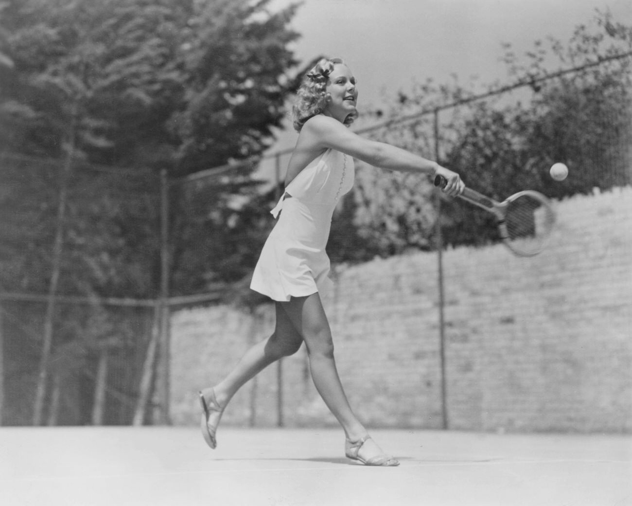 Sonja Henie Playing Tennis In A White Sharkskin Suit, 1938.