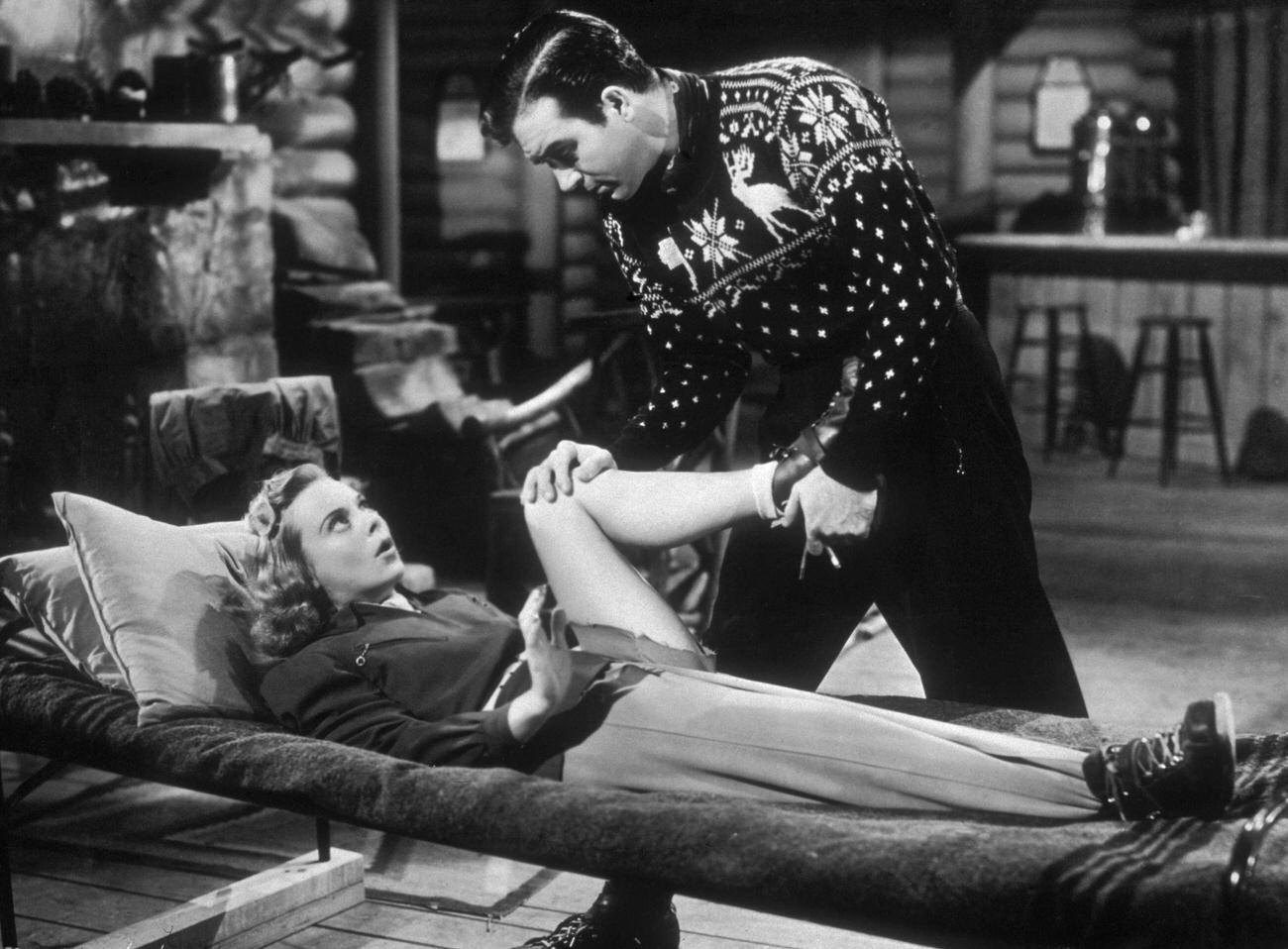 John Payne Attends To Sonja Henie'S Leg In 'Sun Valley Serenade', 1941.