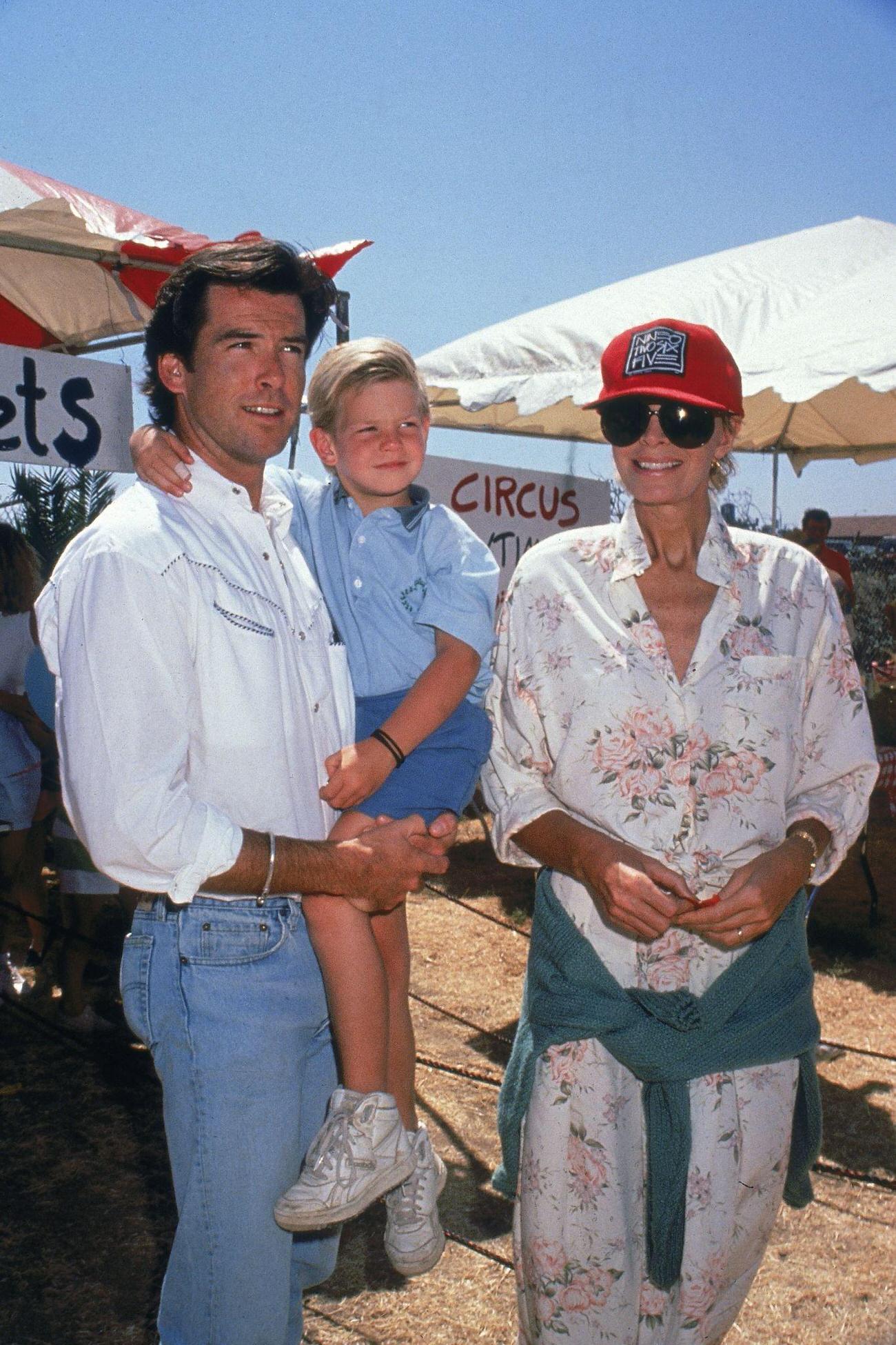 Pierce Brosnan Carrying Son Sean With Wife Cassandra, September 1989.