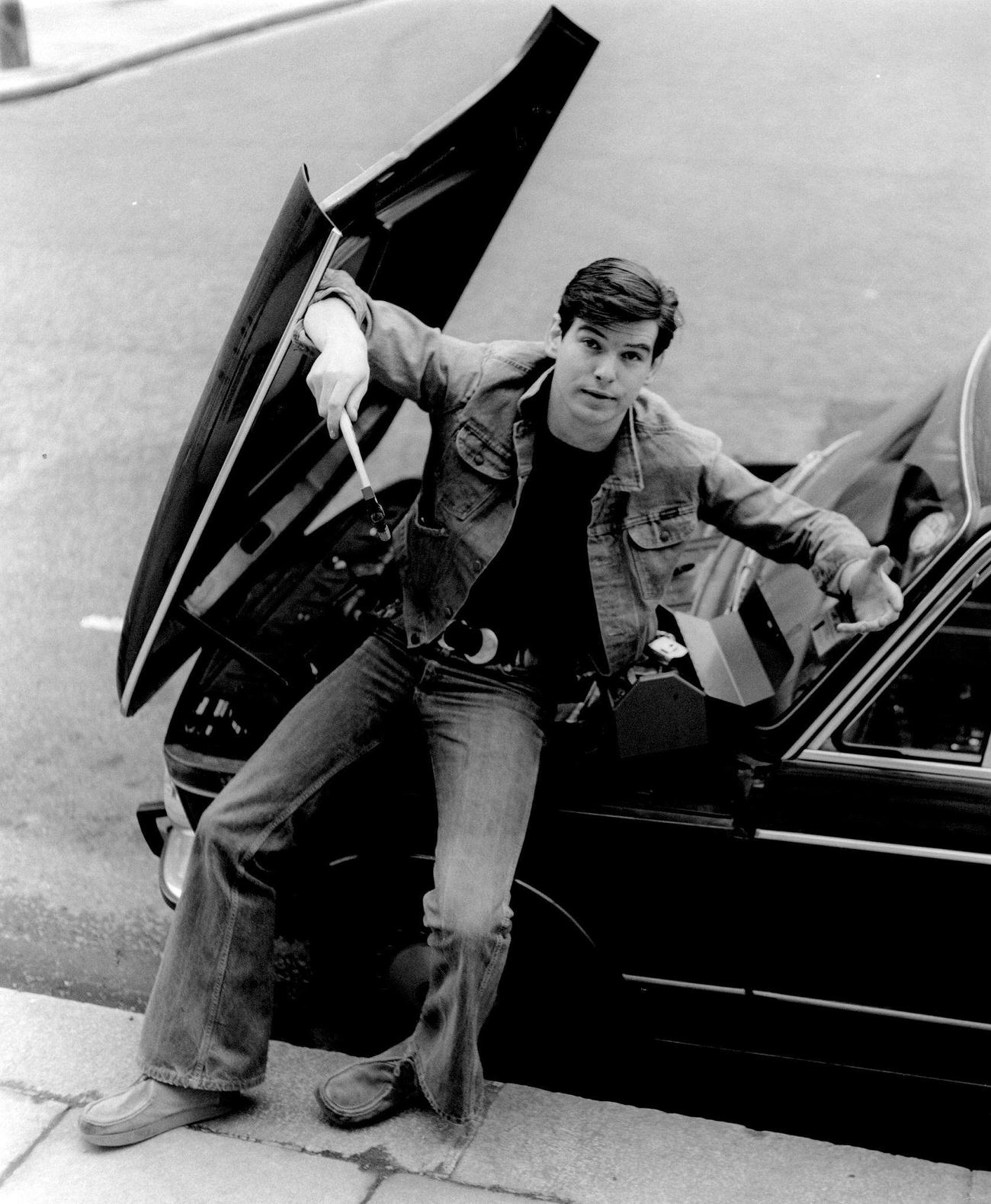 Pierce Brosnan With A Wrench Under A Bmw'S Open Bonnet, London, Circa 1978.