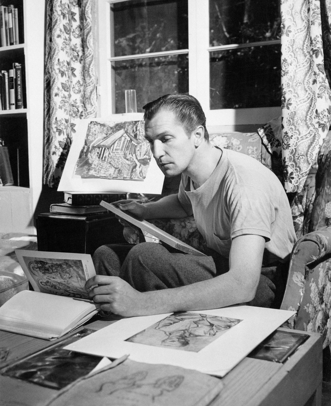 Vincent Price Looking Through Artworks In His Collection, Circa 1950.