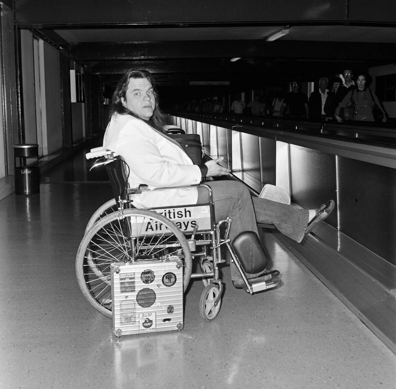 Meat Loaf Leaving Heathrow Airport In A Wheelchair, 1985.