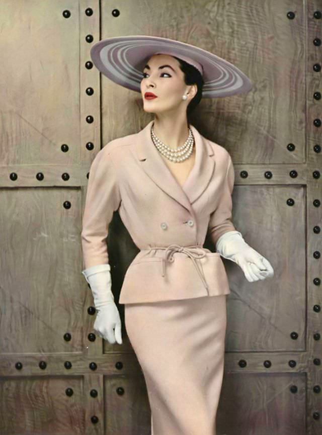 Lucie Daouphars In A Lightweight Glazed Wool Suit, The Jacket Has Rounded Shoulders And A Shawl Collar, Tied At The Waist With Cord Of The Same Material By Pierre Balmain, 1954.