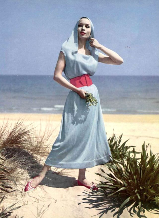 Model In Long Hooded Tunic Of Knitted Silk, Worn With Contrasting Wide Red Leather Belt, By Jacques Heim, Shoes By Charles Jourdan, Photo By Philippe Pottier, 1959