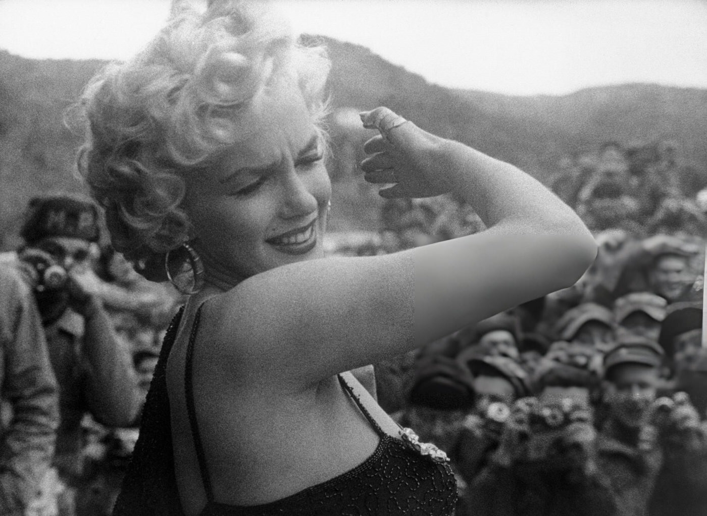 Marilyn Monroe Shielding Her Eyes From Flashbulbs While Entertaining Us Troops, 1954.