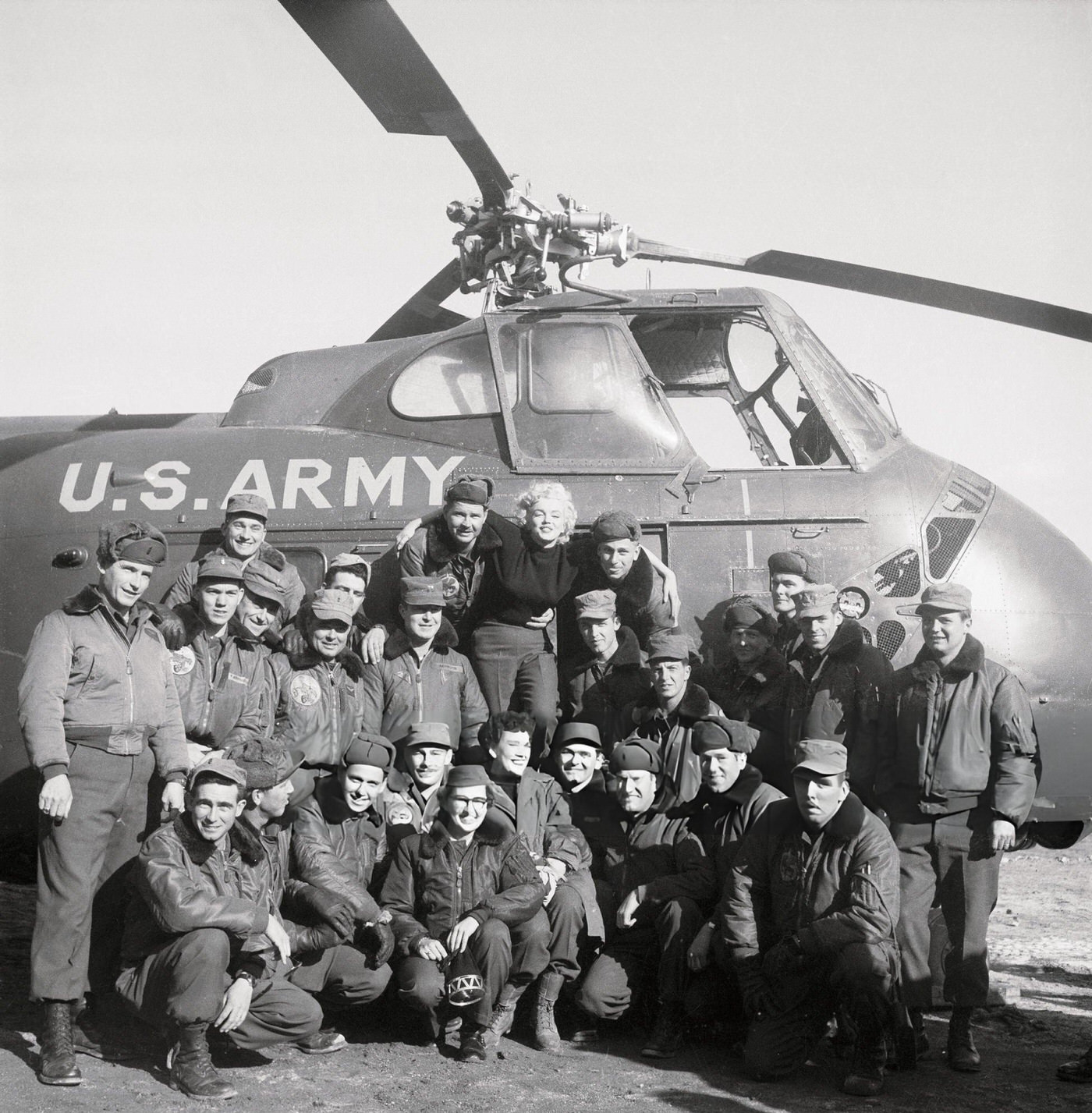 Marilyn Monroe Stands With Several Army Airmen And A Helicopter, 1954.