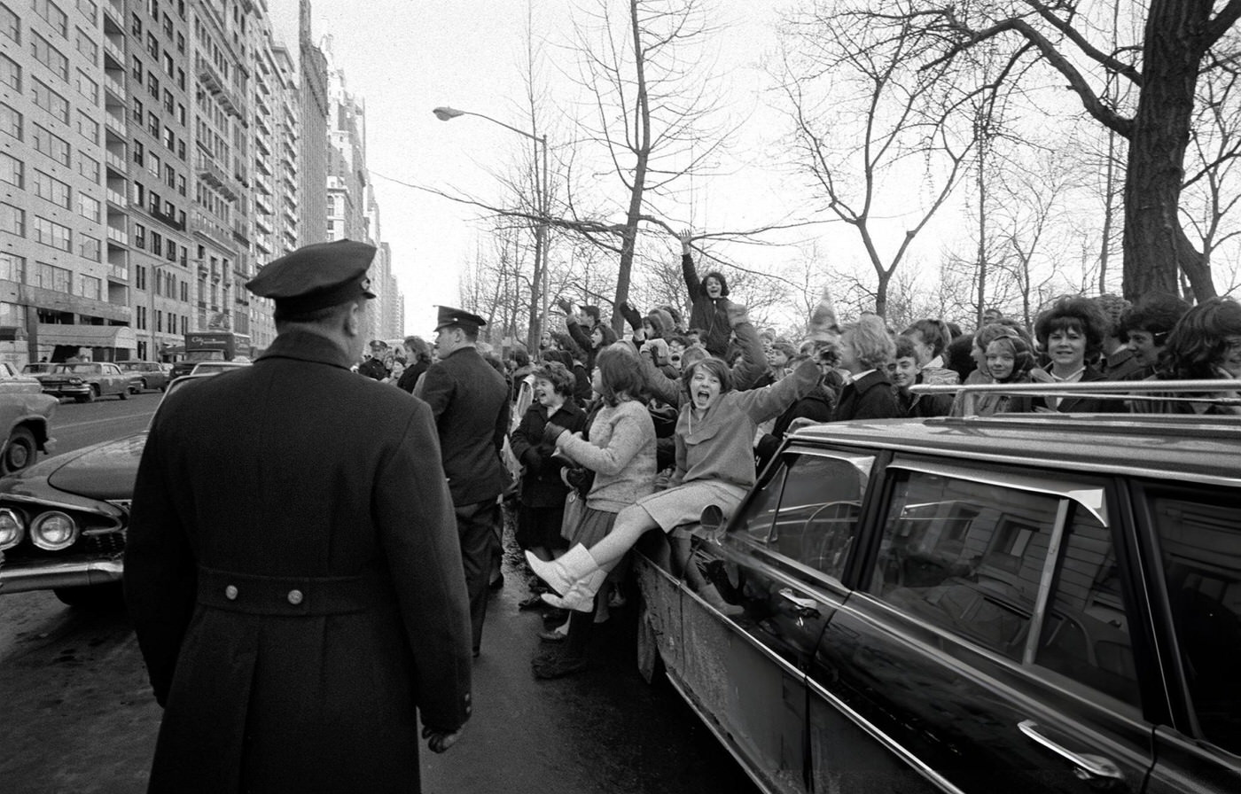 Policemen Keep Watch As Enthusiastic Young American Fans Of British Pop Group The Beatles Surround The Band'S Limousine During The Band'S Tour Of The Usa.