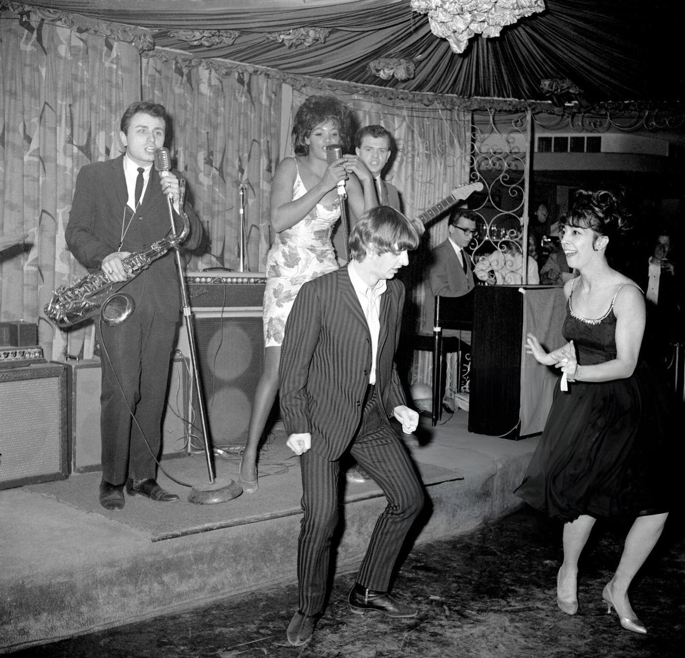 Beatles Drummer Ringo Starr Lets Another Group Do The Performing As He Dances With Jeanie Dell, A Singer At The Headline Club, 1964.