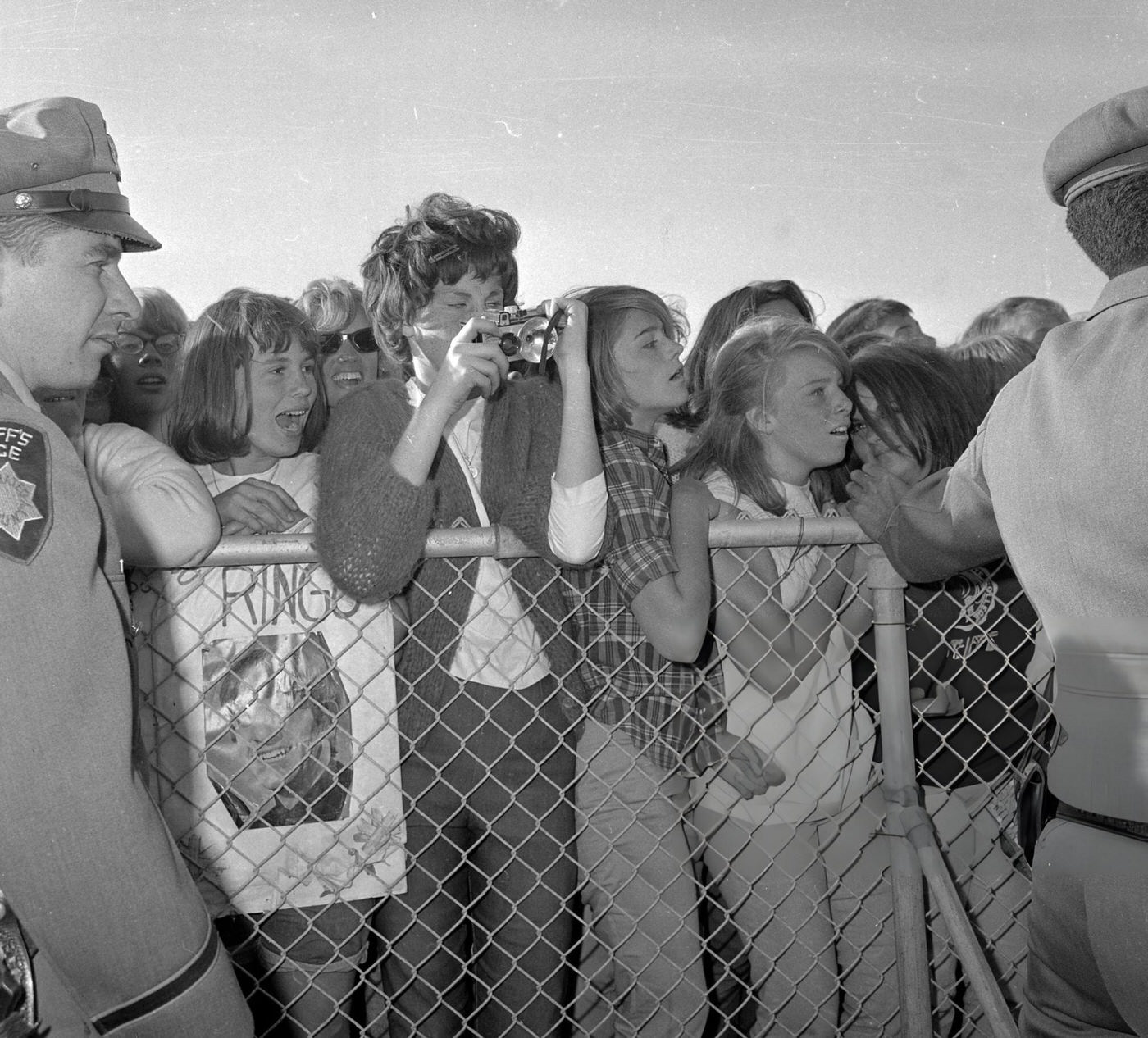 Police Try To Maintain Order As Crowds Of Fans Wait For The Beatles At San Francisco International Airport.