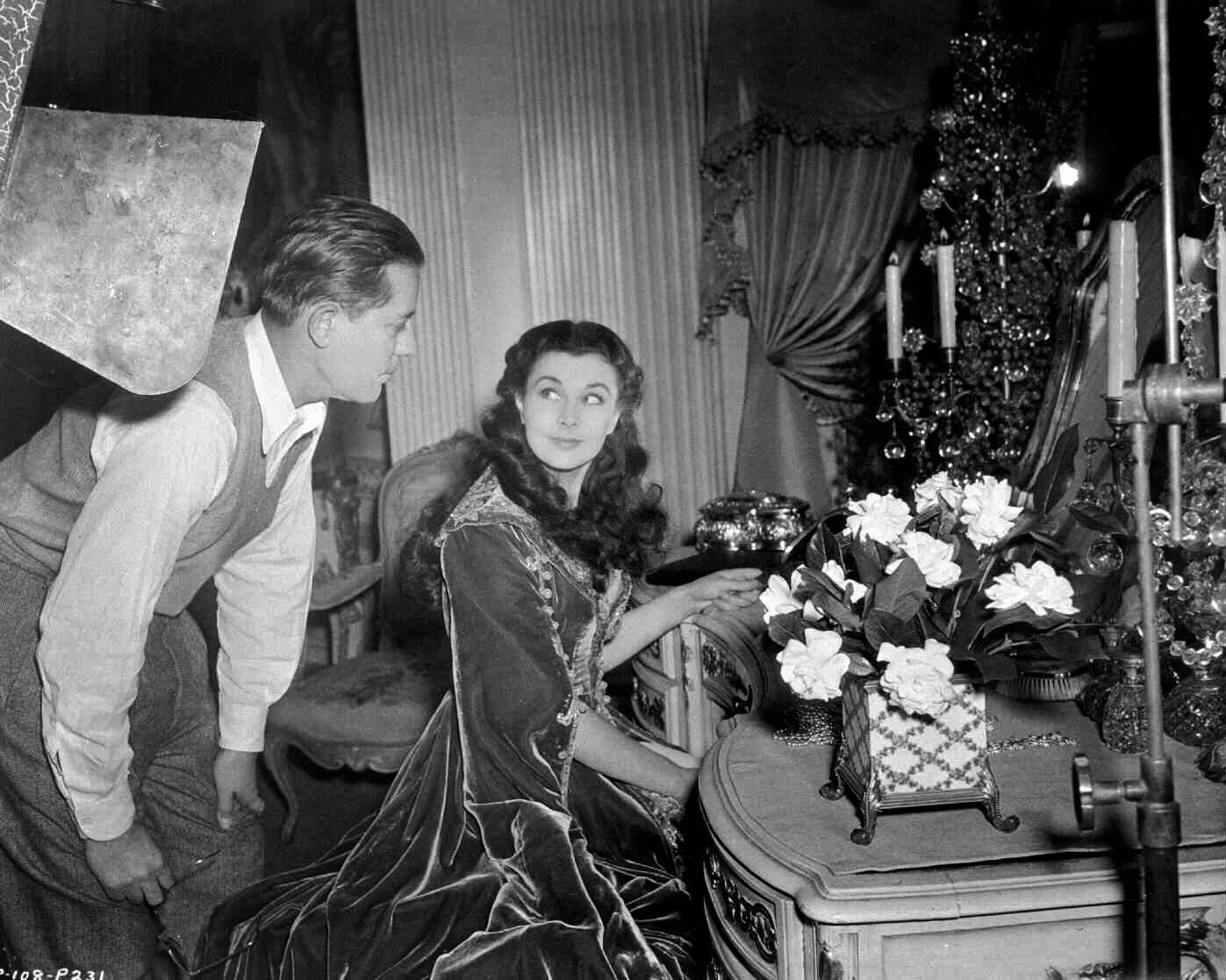 Vivien Leigh As Scarlett O'Hara, Seated At Dressing Table, With Lighting Man Leaning Over Sholder.