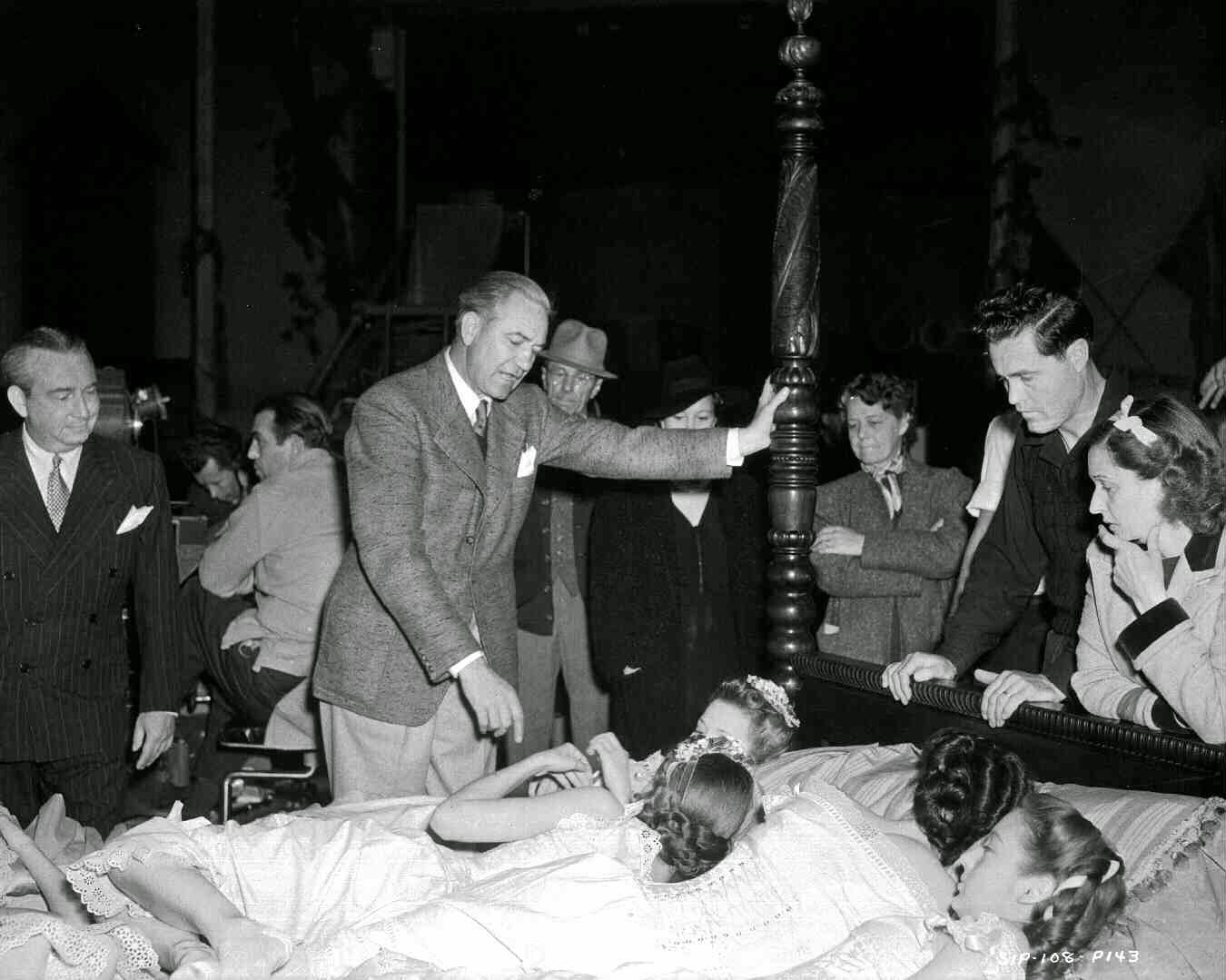 Director Victor Fleming Leaning Against Bed Post, Technical Advisor Susan Myrick, And Crew Members Looking At Girls In Bed.