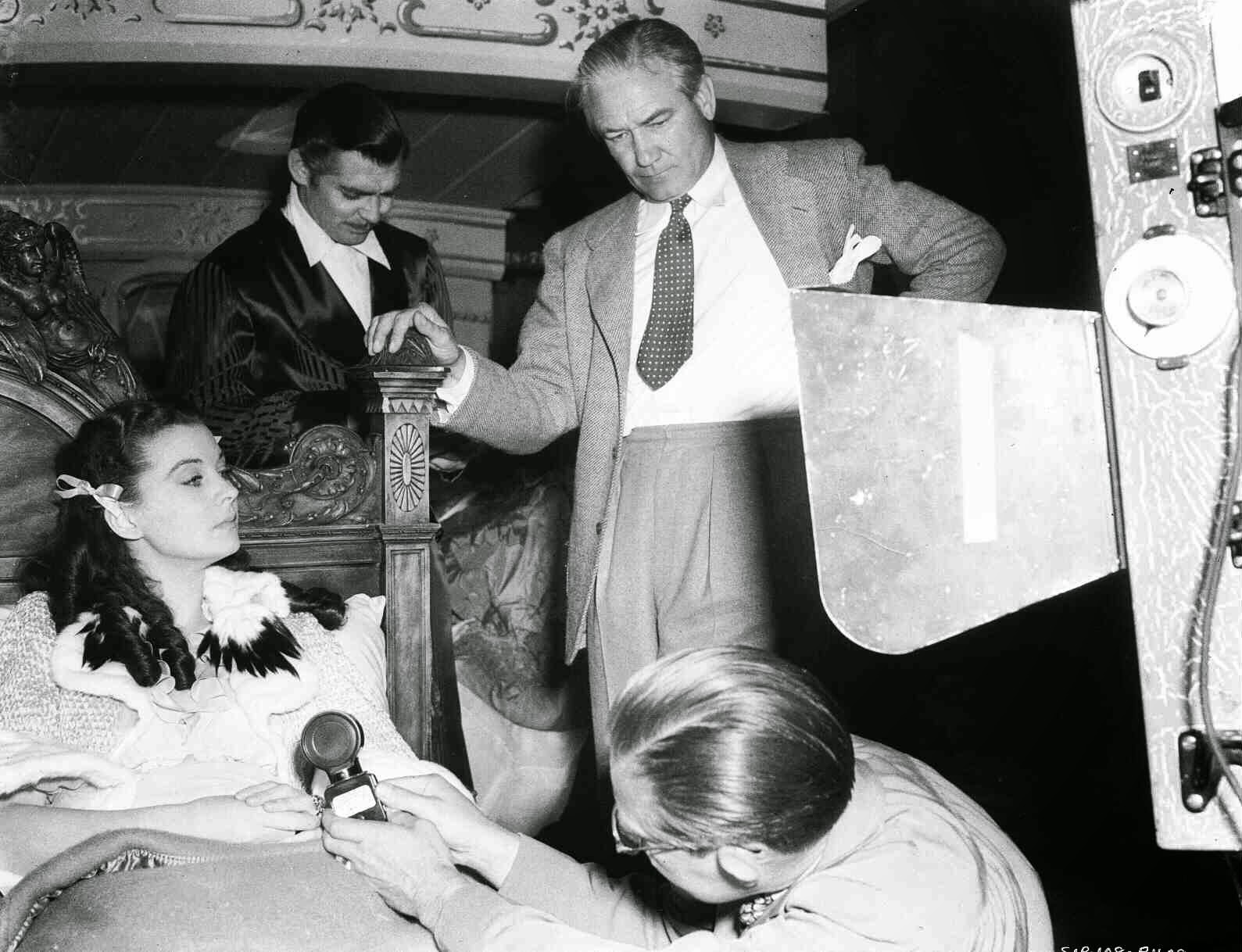 Vivien Leigh As Scarlett O'Hara Laying In Bed, Clark Gable As Rhett Butler, Director Victor Fleming And Man Holding Light Meter.