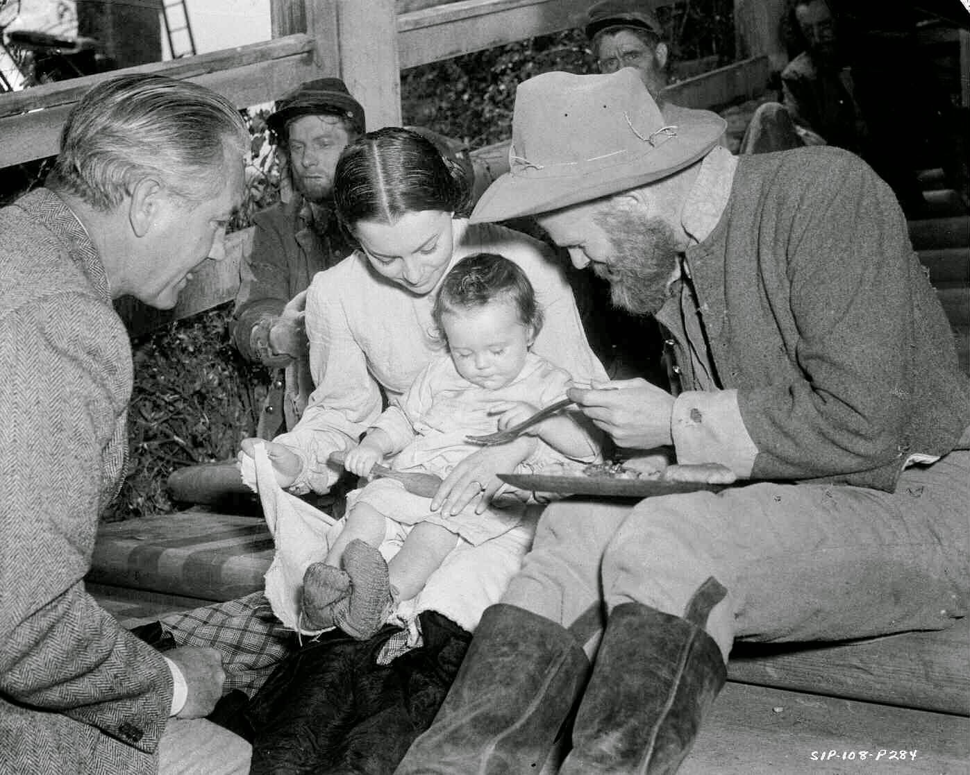 Olivia De Havilland As Melanie Hamilton, With Ric Holt As Beau Wilkes (11 Months) Seated On Her Lap. Seated Alongside Is Phillip Trent As A Hungry Solider, And Director Victor Fleming.