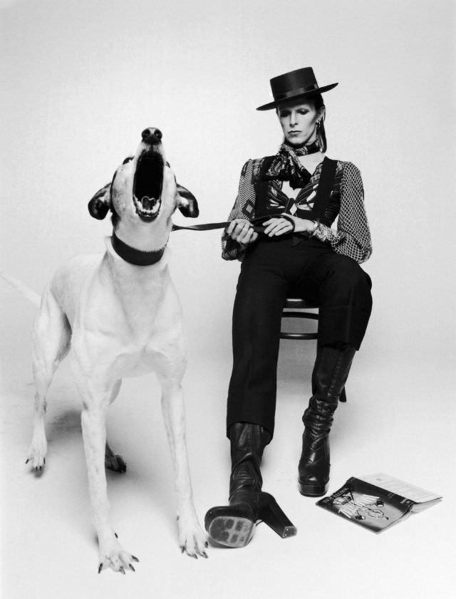 In A Top Hat, Heeled Boots, And Overalls Posing His Album Diamond Dogs, 1974.