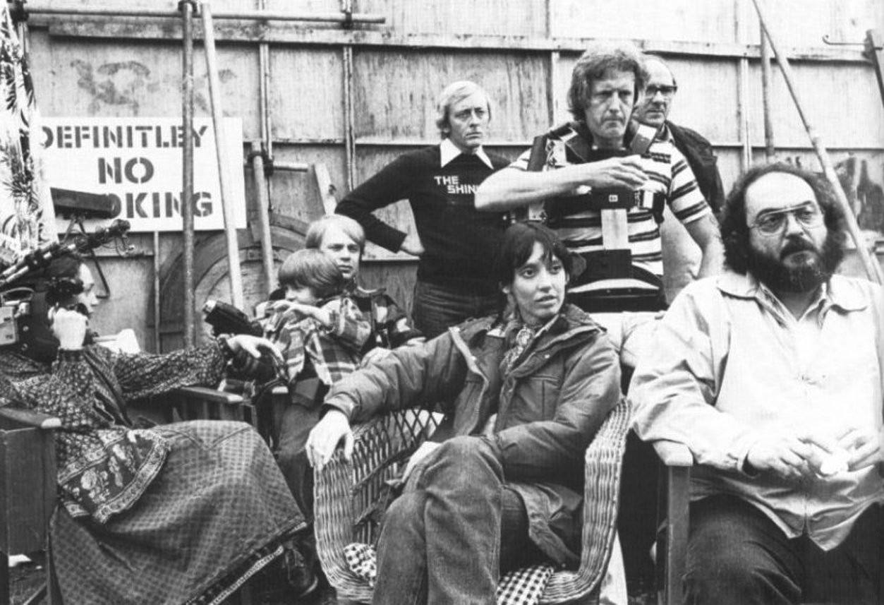 Stanley Kubrick, Shelley Duvall, Danny Lloyd Sits In The Lap Of His On-Set Coach And Longtime Kubrick Assistant Leon Vitali. To The Left, Kubrick’s Daughter Vivian Holds The Camera She Used To Film The Making Of The Shining Documentary. Behind Them, Steadicam Inventor Garrett Brown Stands With Camera Operator Kelvin Pike And Another Unidentified Crew Member.