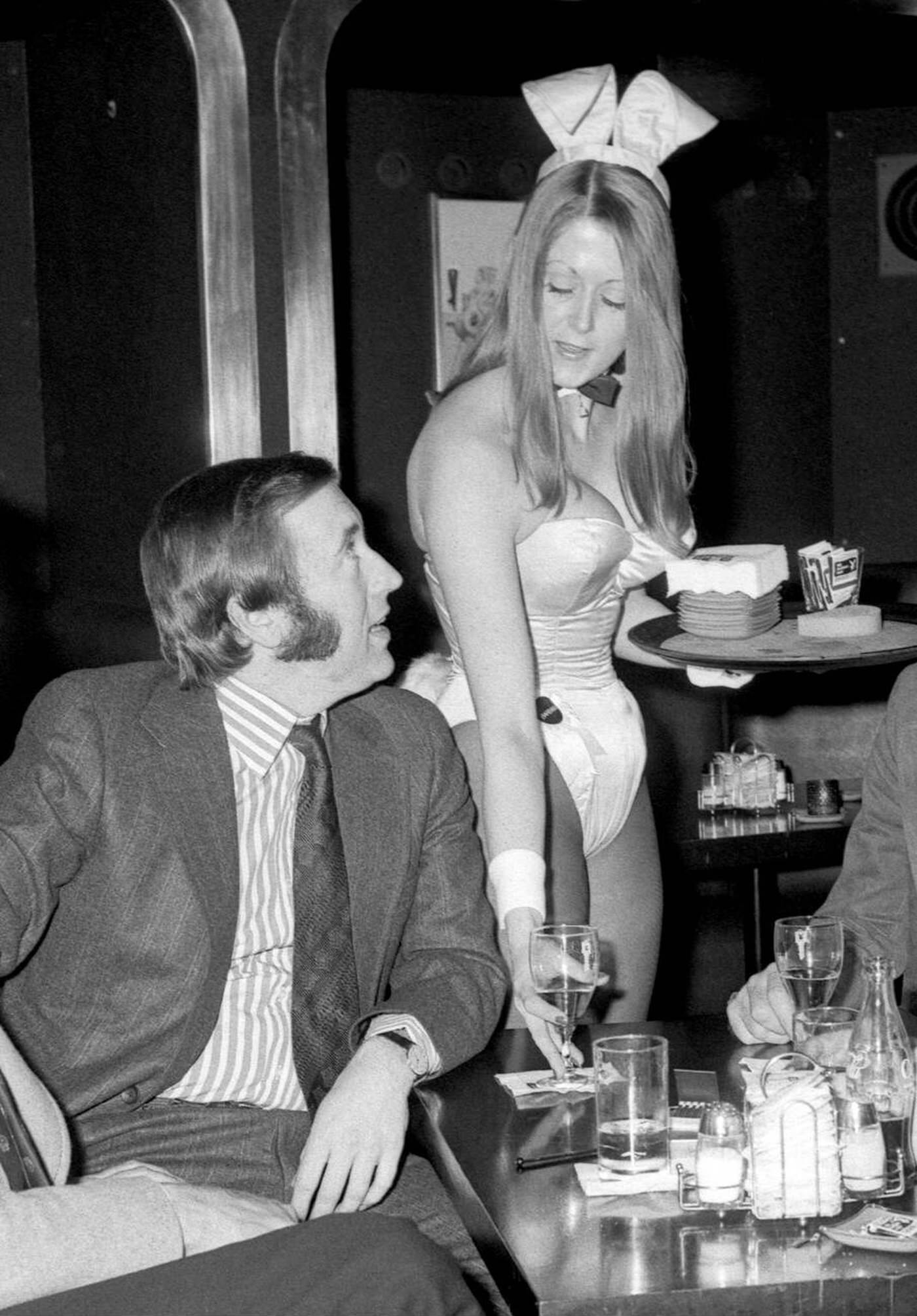 David Frost Enjoys Himself At The Playboy Club In London, As A Bunnygirl Serves Him A Drink, 1973.