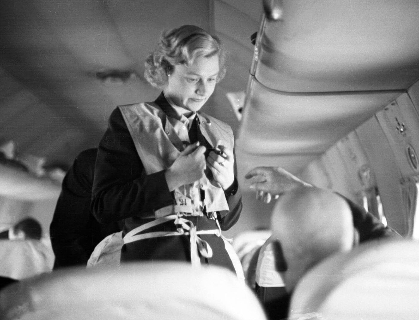A Flight Attendant Demonstrates Life Jackets And Other Security Procedures, Sas Flyrute Copenhagen / New York, 1948.