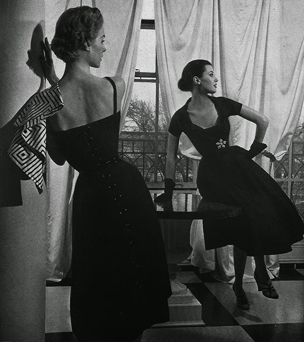 A Model Is Wearing A Rod Of Black Linen, Buttoned Down The Back, With A Triangle Of Black And White That Can Wrap Its Bareness, By Anna Miller; Barbara Mullen Is Wearing Fathoms Of Black Silk, A Deep-Necked Dress With A Slight Collar, By Sally Milgrim, 1952